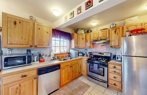 Florissant House | A-frame home lined by trees with wood stove, balcony, children's items, & W/D