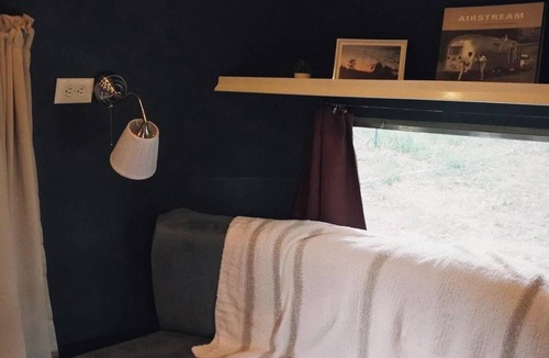 Larkspur House | Cozy camper by the creek, surrounded by serenity and nature.